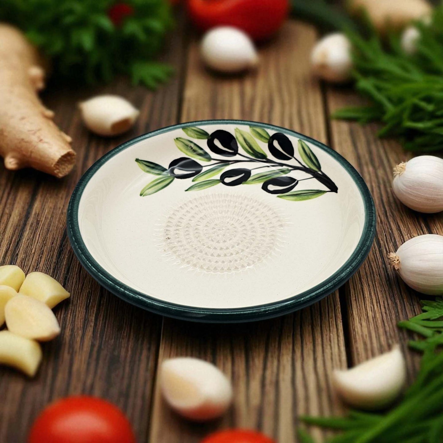 Ceramic garlic grater bowl with olive design on a wooden surface with vegetables