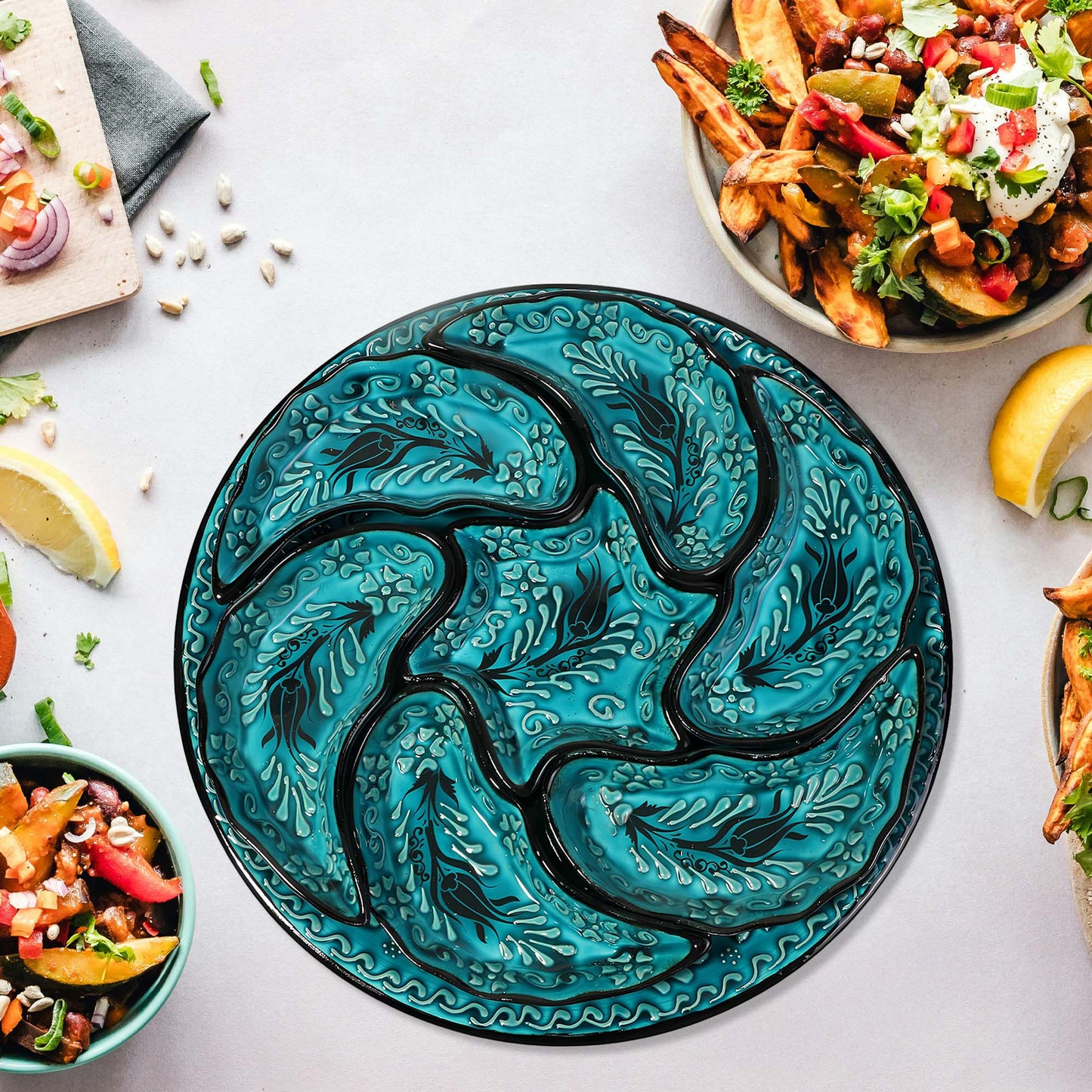 Decorative teal snack serving tray set with wavy patterns on a table with food.