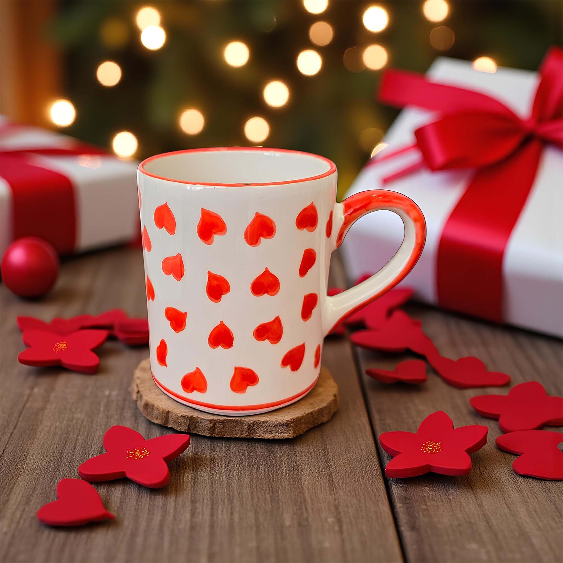 Mug with red heart pattern coffee mug on a wooden surface with Christmas decorations