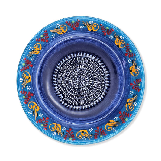 Decorative blue garlic grater bowl with colorful patterns on a white background