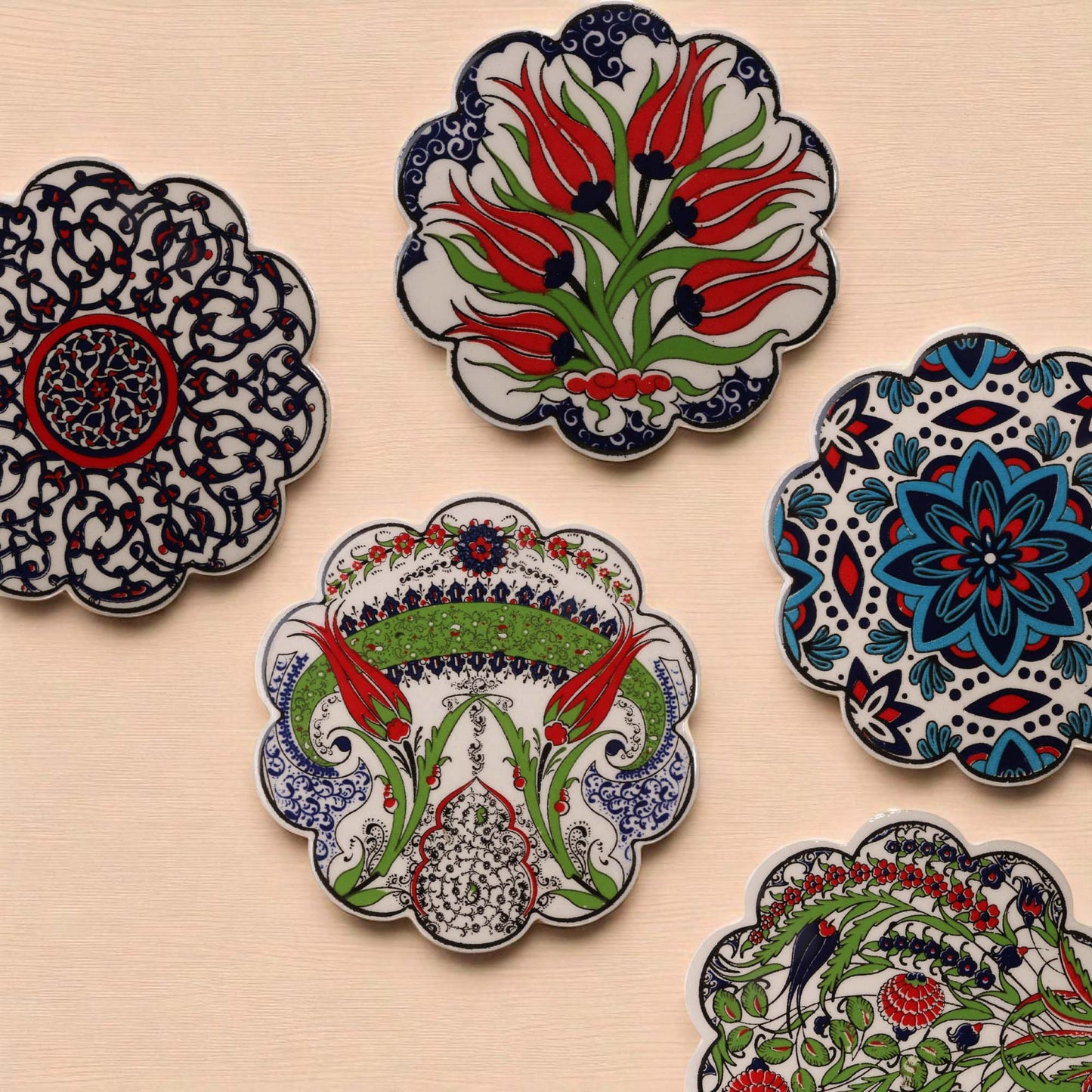 Decorative ceramic coasters with floral patterns on a beige surface