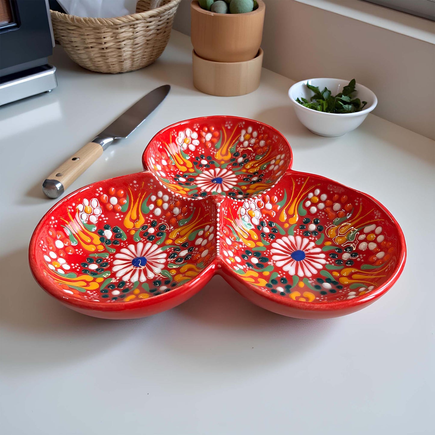 Colorful ceramic bowls on a kitchen counter with a knife and small bowl of greens.