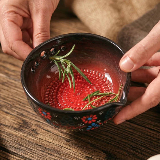 Decorative herb stripping bowl with floral patterns and rosemary on a wooden surface