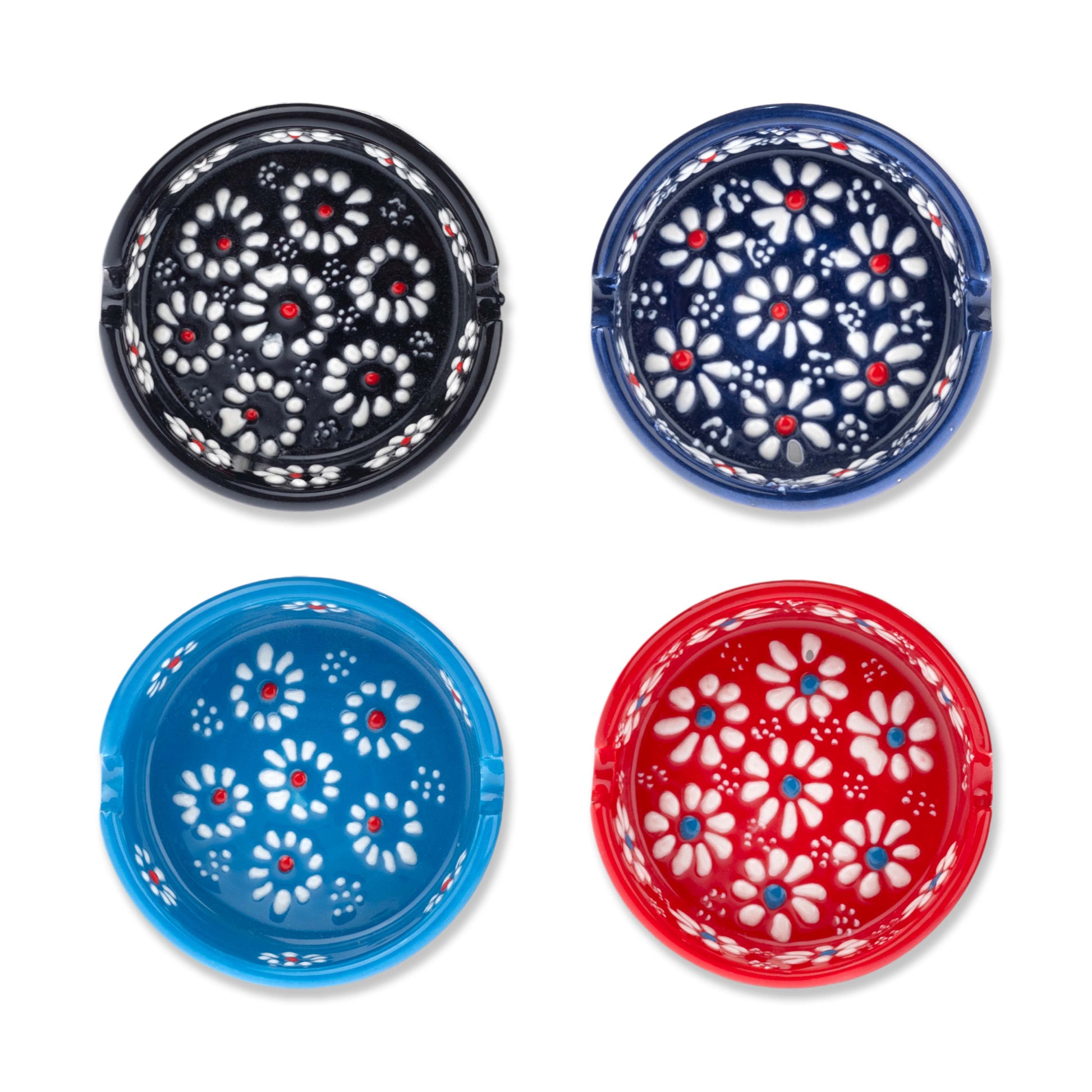 A set of four hand-painted ceramic ashtrays, two in blue with white flowers, and two in red with white flowers, displayed against a white background.