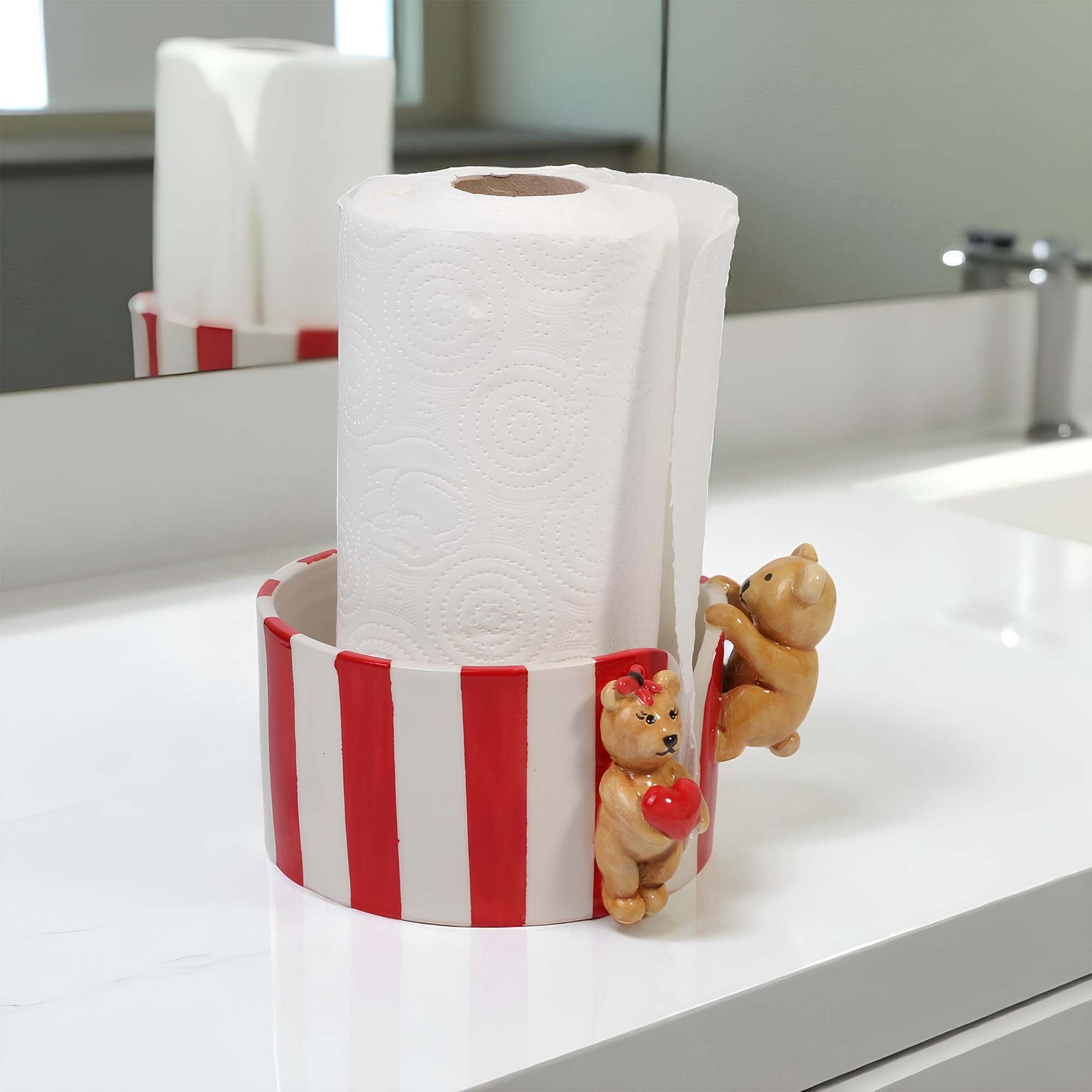 Red and white striped paper towel holder with teddy bear design on a kitchen counter.
