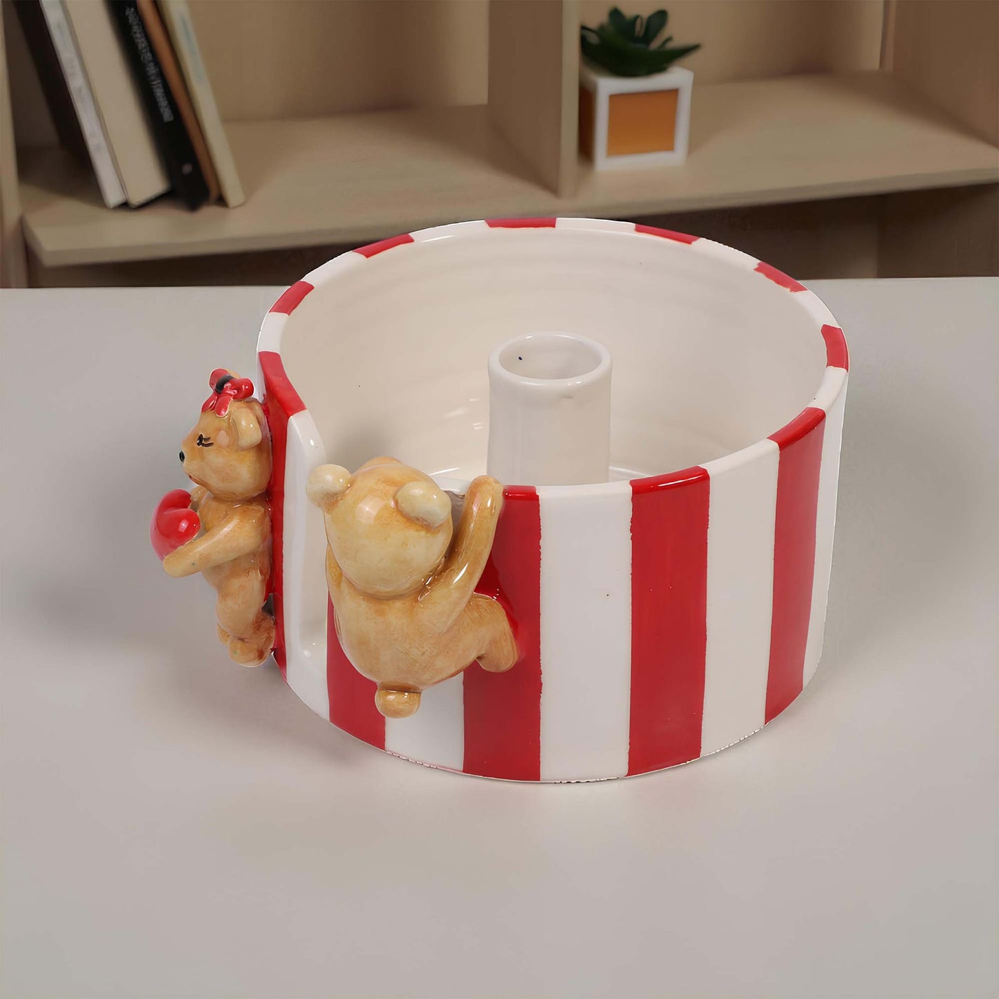 Decorative paper towel holder with red and white stripes and bear figurines on a plain surface.