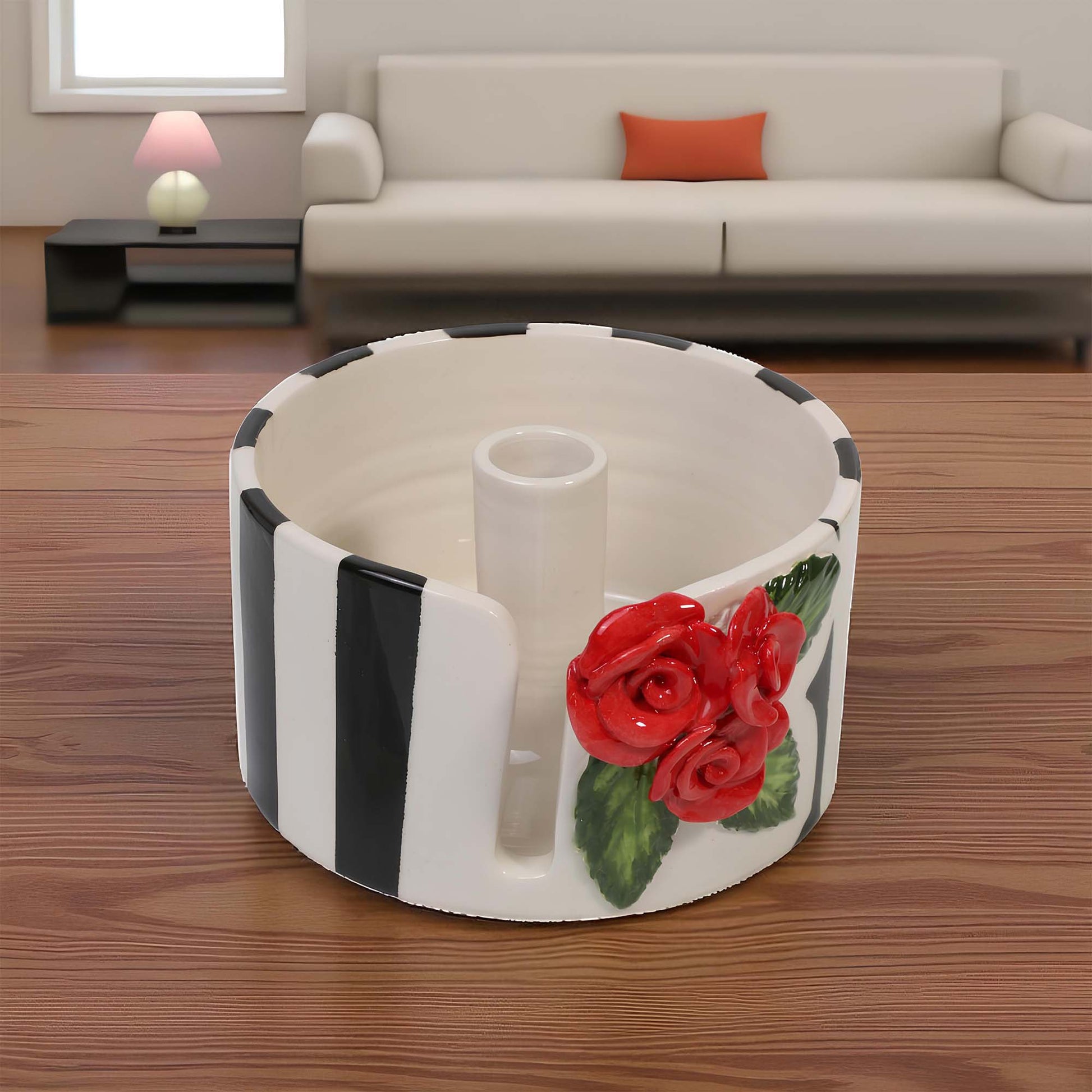 Decorative paper towel holder with red roses on a wooden floor in a living room setting