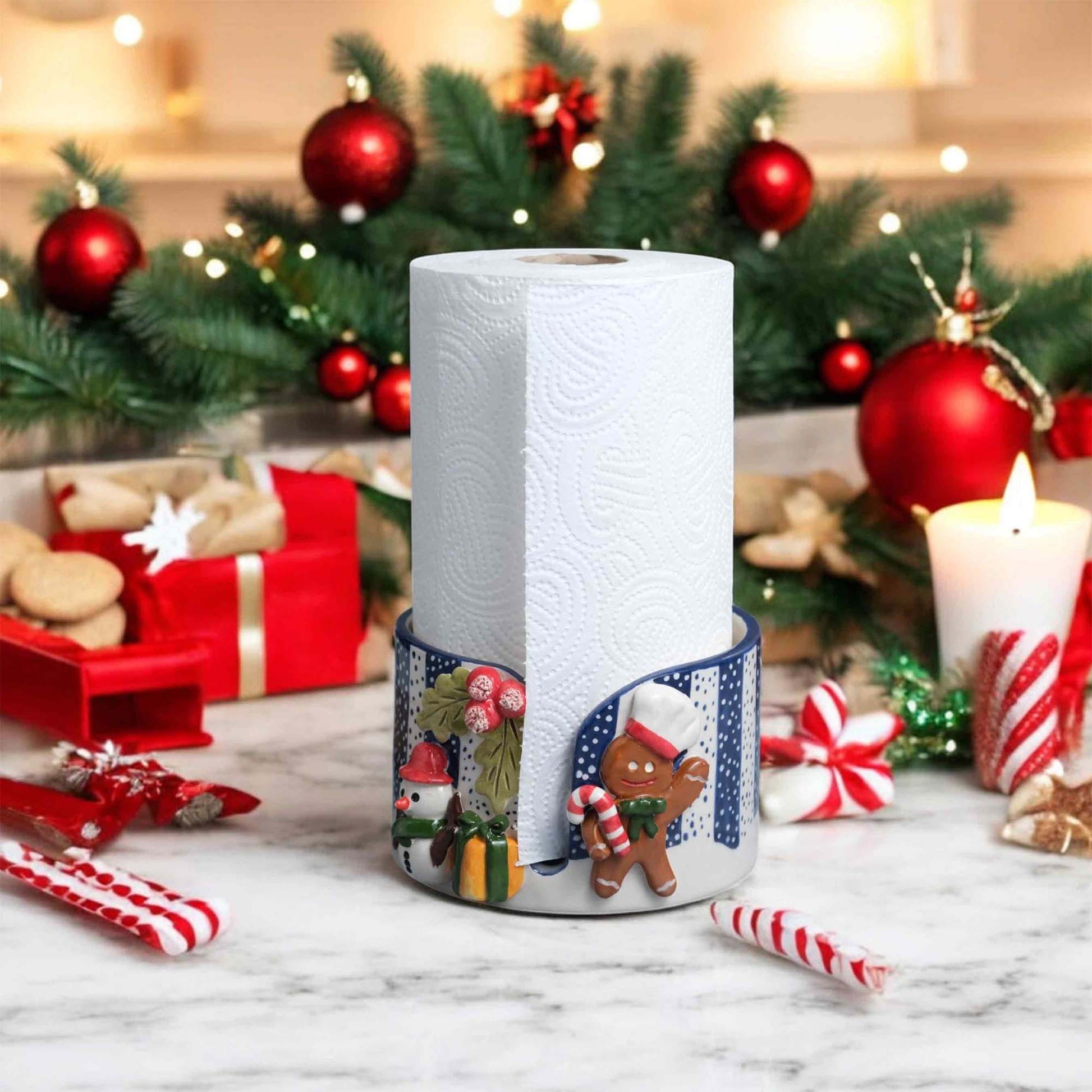 Decorative paper towel holder with gingerbread design in a festive setting with Christmas decorations.