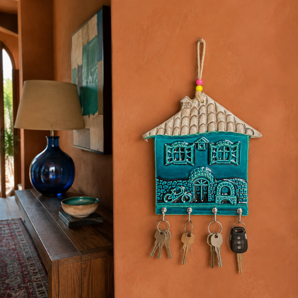 Turquoise ceramic house wall key holder with 4 hooks in a boutique foyer