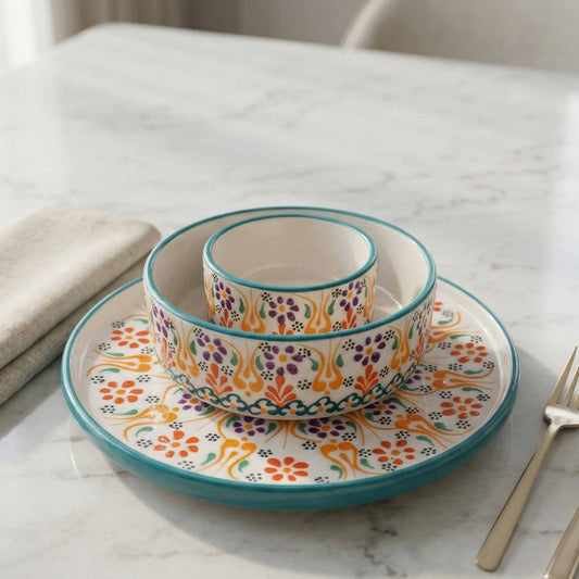 Colorful ceramic bowls and plate set on a marble surface with a fork.