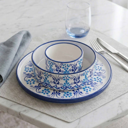 Set of blue and white ceramic dishes on a table with a glass and fork.