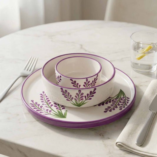 Ceramic tableware set with purple floral design on a marble surface