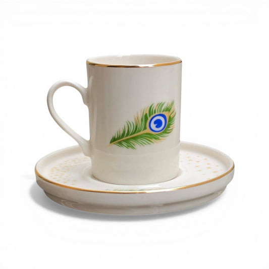 Porcelain cup and saucer with a peacock feather design on a white background