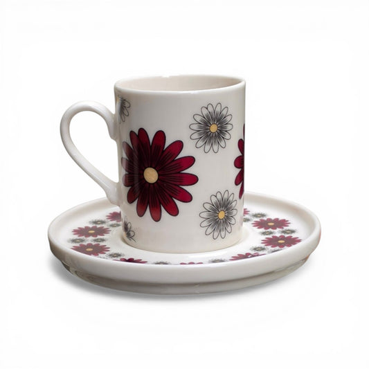 Porcelain cup and saucer set with floral design on a white background