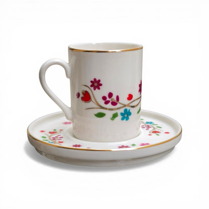Porcelain cup and saucer with floral designs on a white background