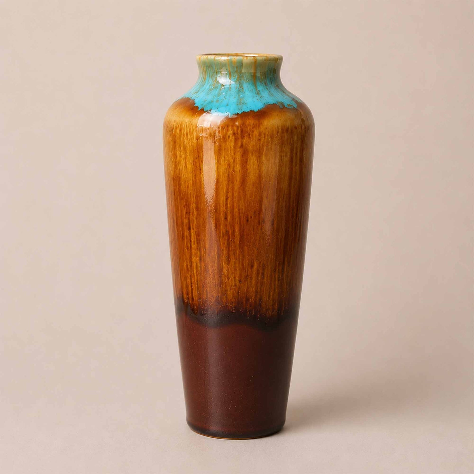 Tall ceramic vase with a gradient color from brown to blue on a beige background