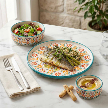 Dinner setting with fish dish, salad, and bread on a decorative plate.