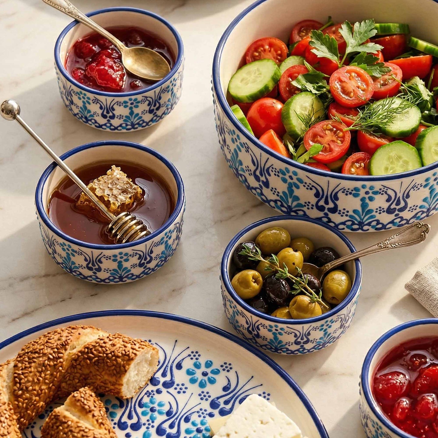 Assorted dishes including a salad, bread, and small bowls with spreads on a marble surface.