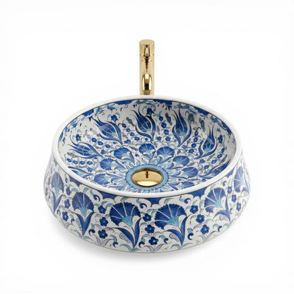 Decorative ceramic sink with blue floral patterns and gold accents on a white background
