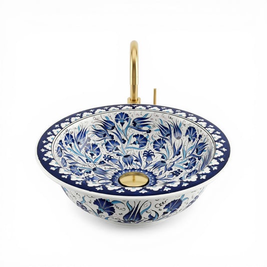 Decorative ceramic sink with blue floral patterns and gold accents on a white background