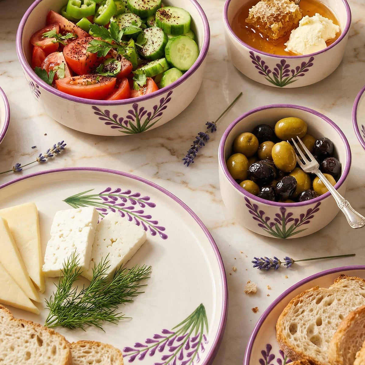 Assorted food items including a salad, olives, cheese, and bread on a marble surface with decorative elements.