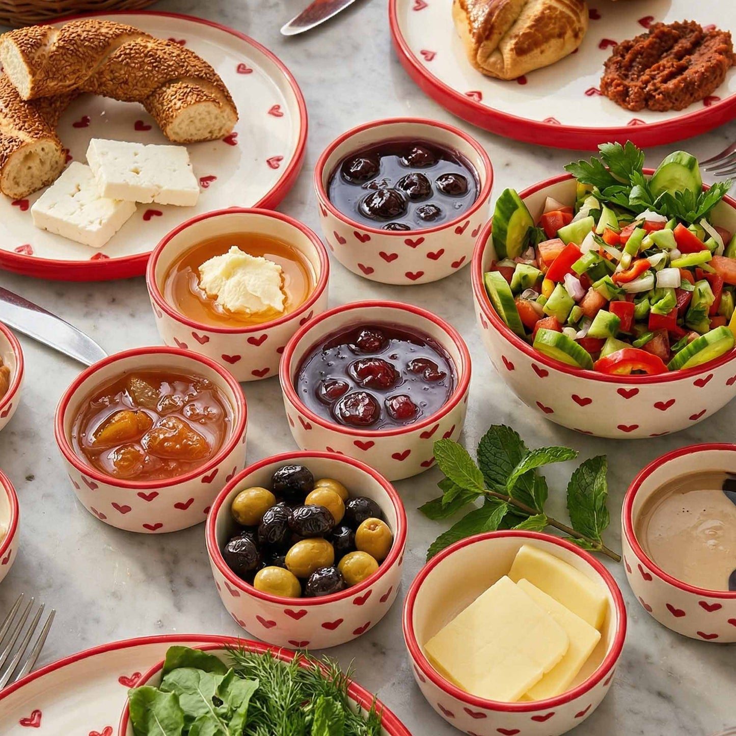 Assorted food items including bread, cheese, and salads served in small bowls on a marble surface.