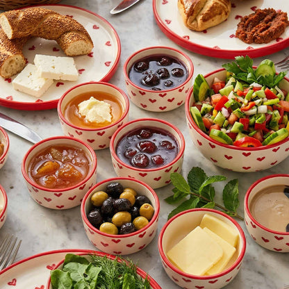 Assorted food items including bread, cheese, and salads served in small bowls on a marble surface.