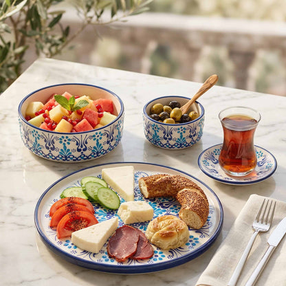 Outdoor setting with a plate of food, fruit bowl, and tea on a marble surface.