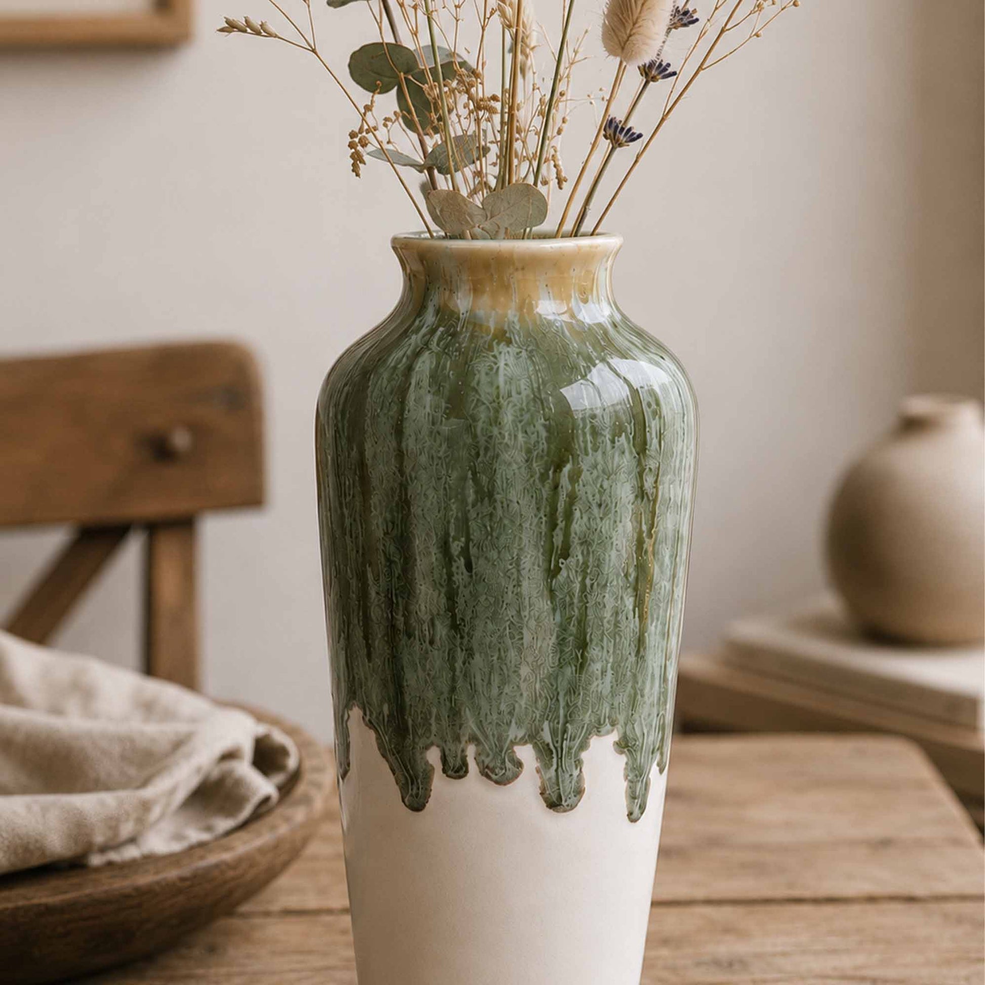 Green ceramic vase with a textured surface on a wooden table.
