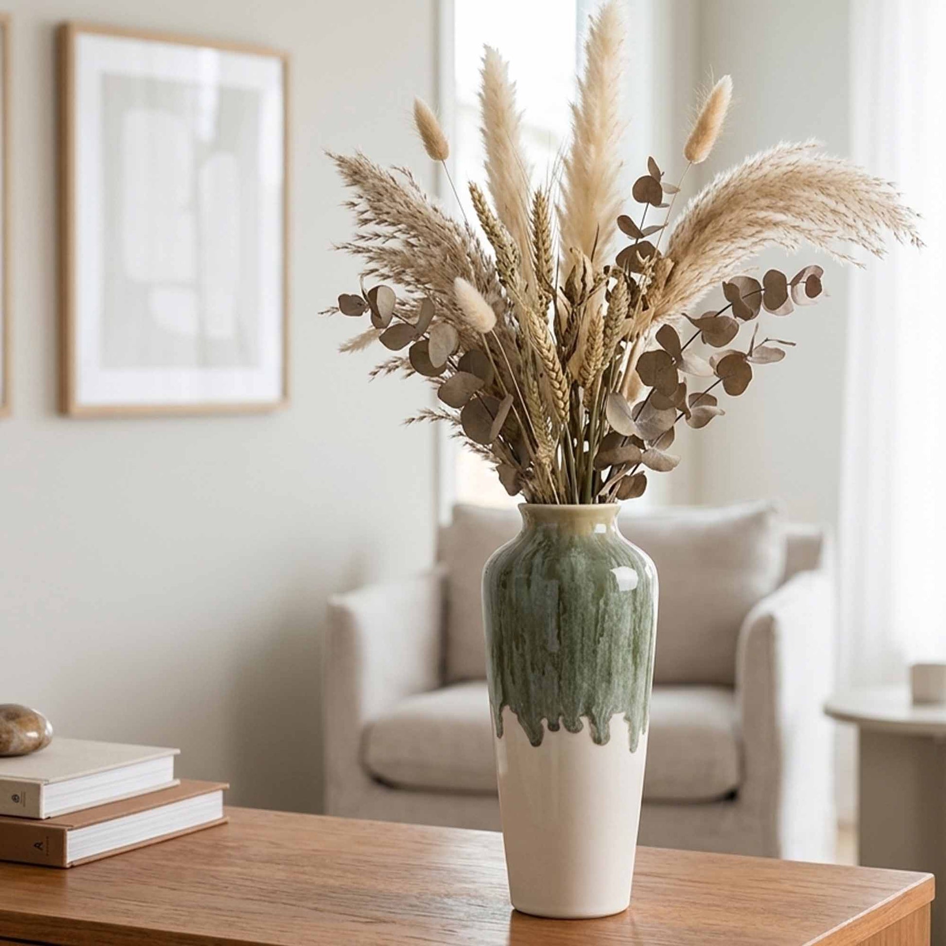 Decorative ceramic vase with dried plants on a wooden table in a living room setting