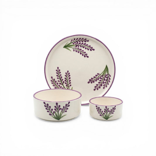 Ceramic dinnerware set with purple plant design on a white background