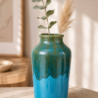 Blue ceramic vase with decorative elements on a wooden surface