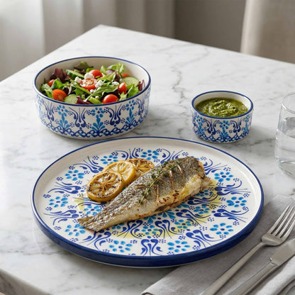Dinner setting with fish dish, salad, and sauces on a marble table.