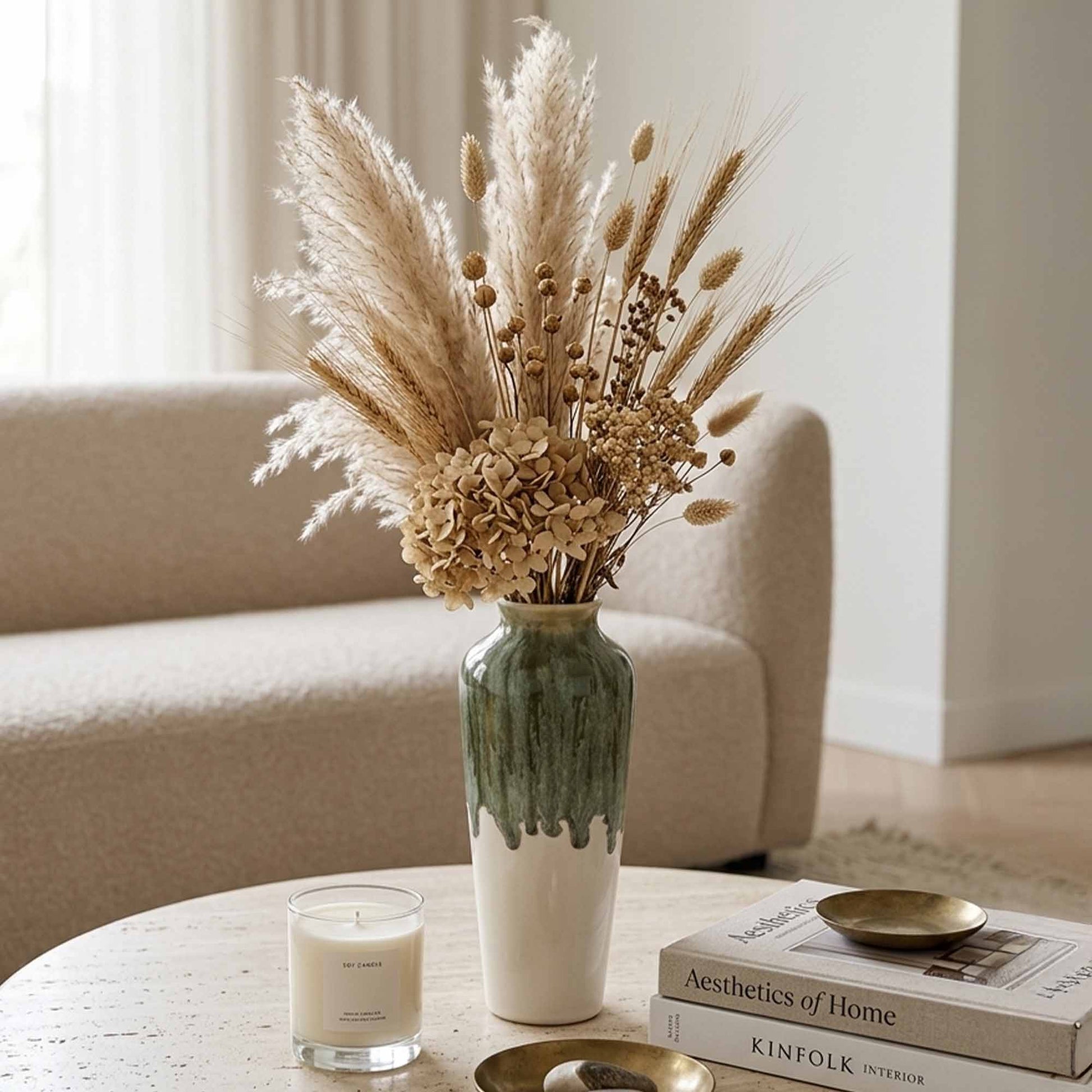 Decorative ceramic vase with dried flowers on a table in a living room setting