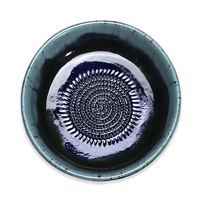 Ceramic garlic grater bowl with decorative pattern on a white background