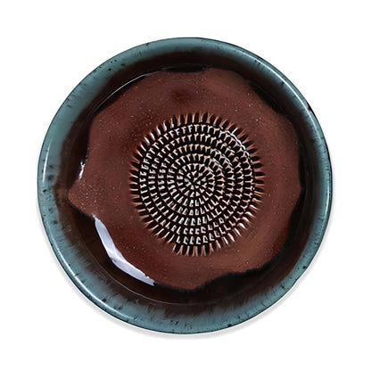 Ceramic garlic grater bowl with decorative design on a white background