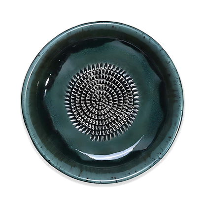 Green ceramic garlic grater bowl with a textured center design on a white background
