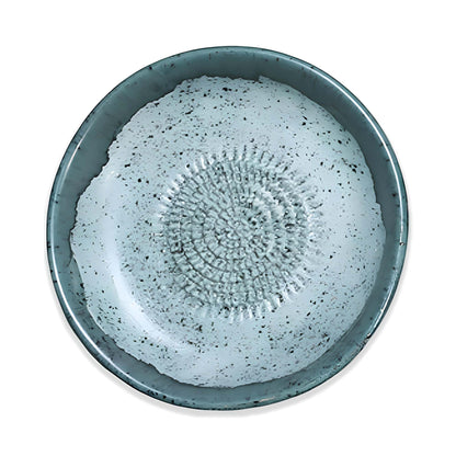 Ceramic garlic grater bowl with textured design on a white background