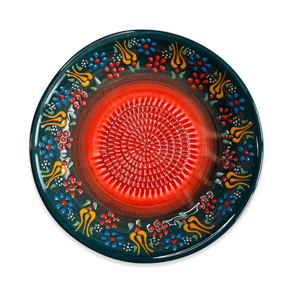Decorative garlic grater bowl with a red center and colorful floral patterns on a white background