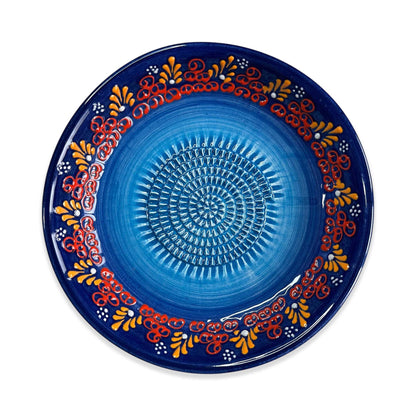 Decorative blue garlic grater bowl with colorful patterns on a white background
