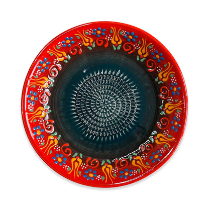 Decorative garlic grater bowl with a red border and colorful patterns on a white background