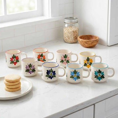 Set of ceramic mugs with floral designs on a kitchen counter.