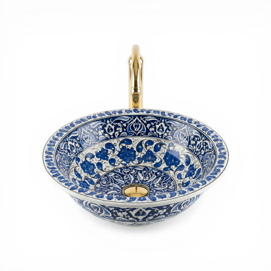 Decorative blue and white ceramic sink with gold accents on a white background