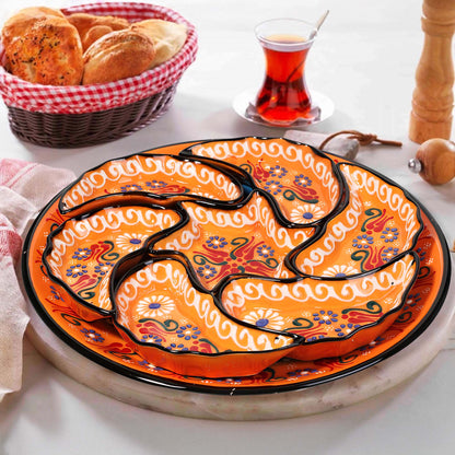 Decorative ceramic snack serving tray set with floral patterns on a white surface, accompanied by a basket of bread and a glass of tea.