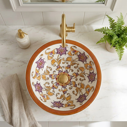 Decorative ceramic sink with floral patterns on a marble countertop.