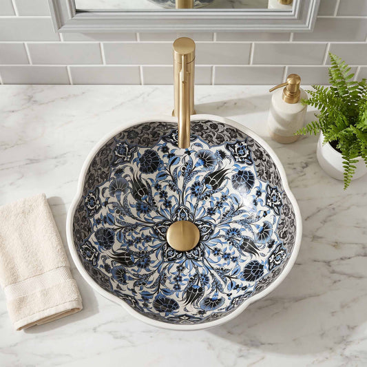 Decorative bathroom sink with floral patterns and gold fixtures on a marble countertop.