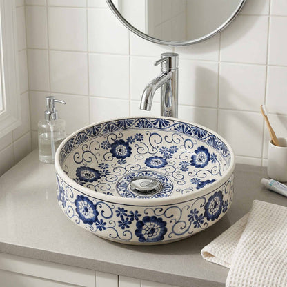 Bathroom sink with blue floral pattern, silver faucet, and toiletries.