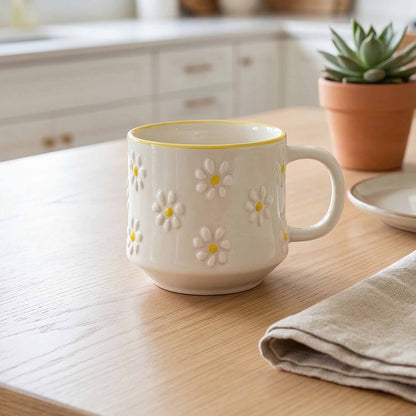 White mug with floral design on a wooden table in a kitchen setting