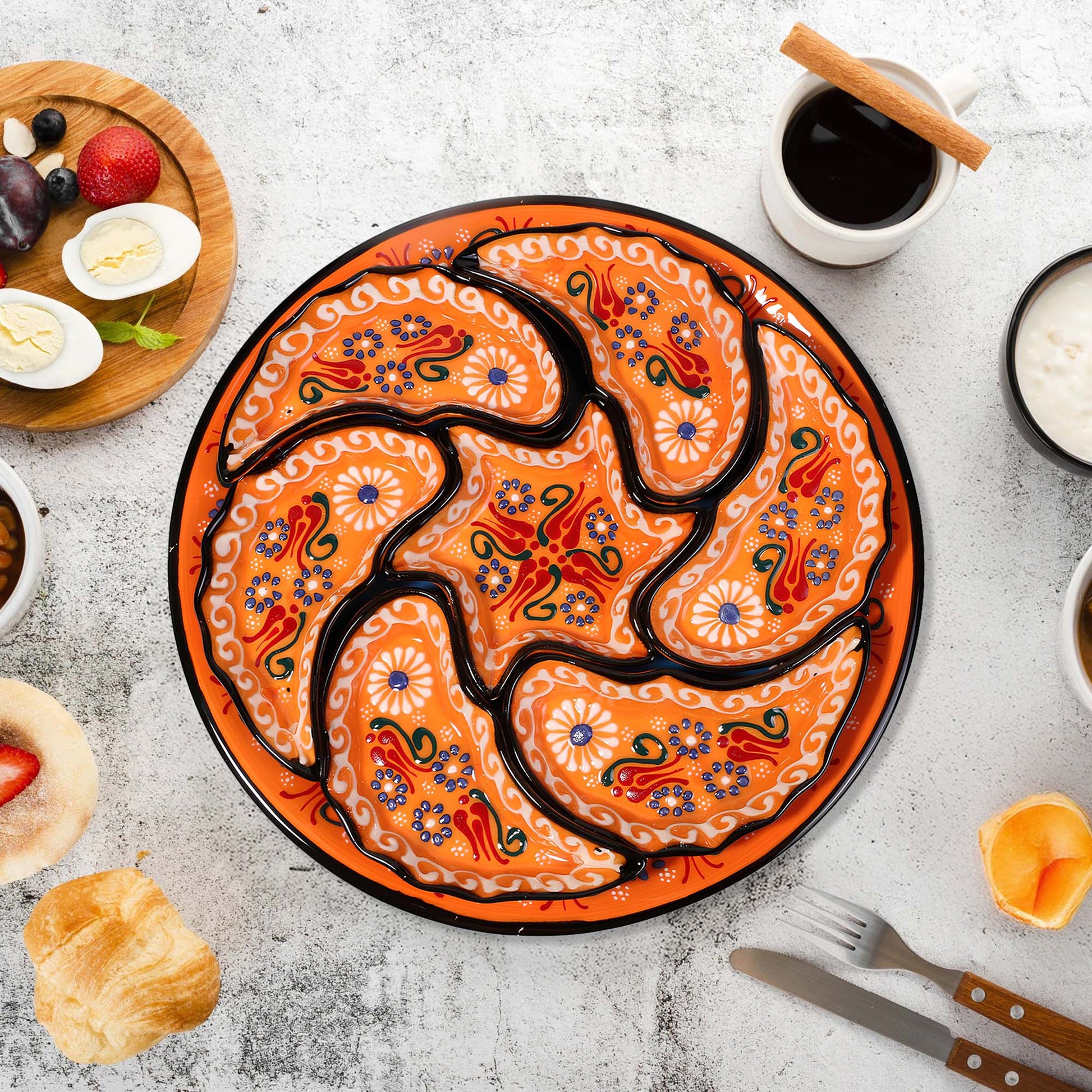 Decorative snack serving tray set with a floral design on a table with food and coffee.
