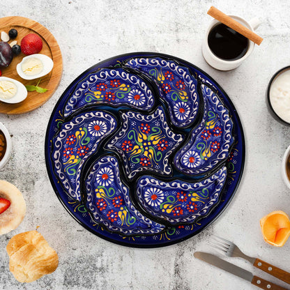 Decorative ceramic snack serving tray set with floral patterns on a table with food items and cutlery.